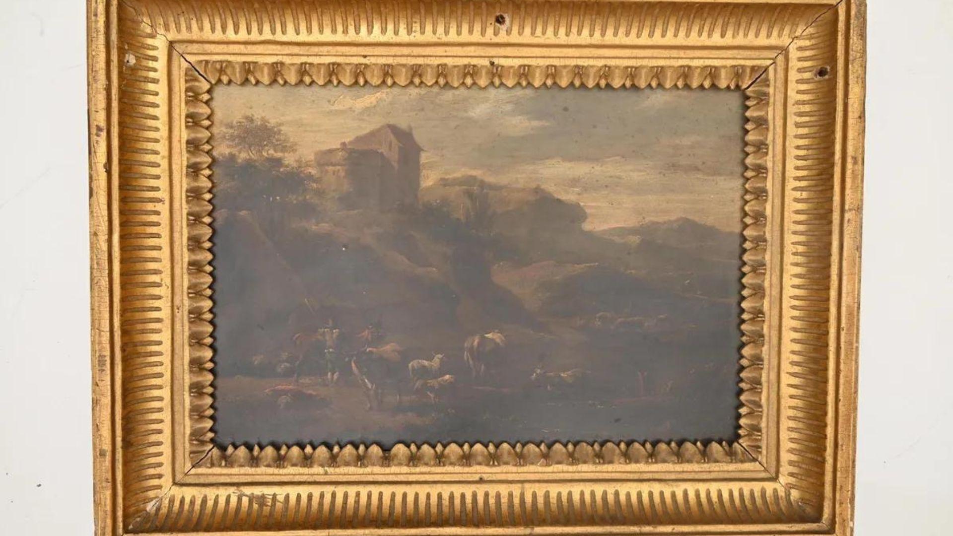 The 'Landscape of Italian Character' painting, portraying a rustic Italian countryside scene with grazing animals and a distant building. It is encased in a detailed gold frame.